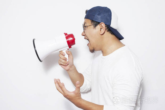 年轻的亚洲人穿着白色衬衫用扩音器喊叫愤怒的表情特写身体肖像侧视