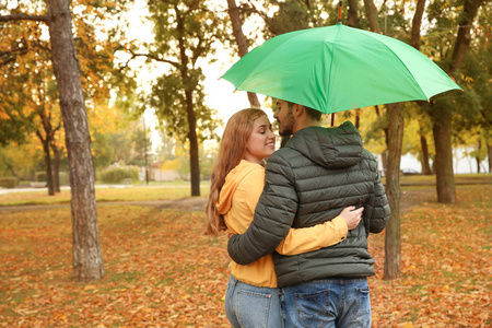 带着雨伞在公园散步的幸福夫妇。 文本空间