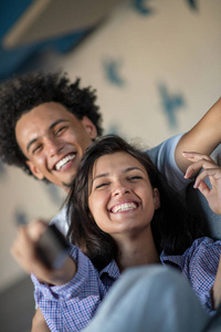 年轻的黑人夫妇在沙发上放松, 对着镜头微笑
