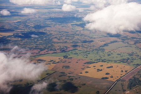 从飞机窗户透过云层来观察地球表面。