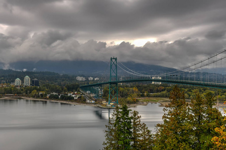 狮子门桥，从斯坦利公园在温哥华加拿大秋叶。 狮子门桥于1938年开放，正式称为第一座窄桥是一座悬索桥。