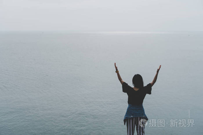 女人举手到天空自由的概念蓝天和夏天的田野背景