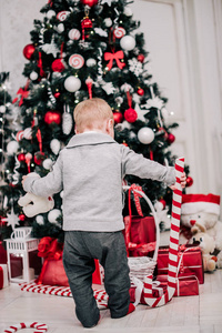 一个小男孩的圣诞画像，壁炉和圣诞树周围舒适的气氛