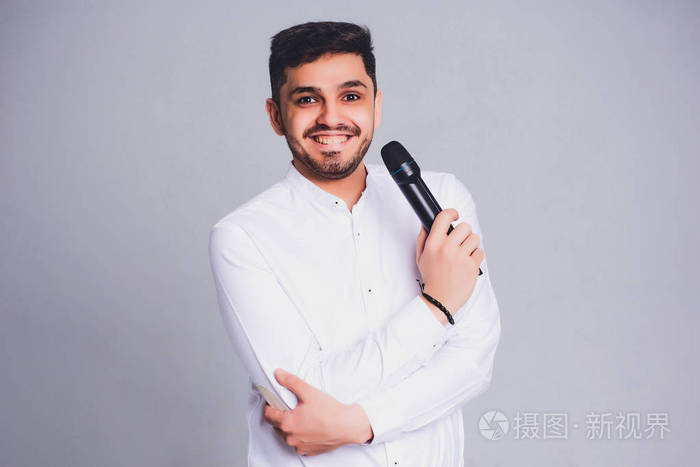 年轻优雅的男子拿着麦克风对白色背景.展示人的概念