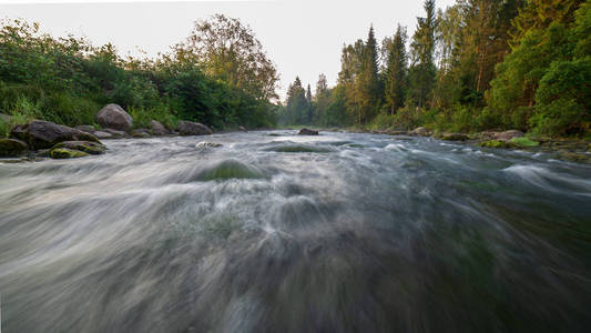 拉脱维亚阿马塔河中的水流，夏季早晨有砂岩峭壁和绿叶