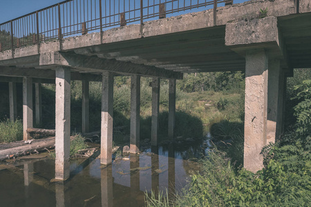 木质复合材料脚桥在绿色夏季森林环境中的水上，带湖复古的外观