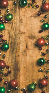 圣诞节新年假期背景纹理壁纸。 绿色红色金色圣诞树装饰球木制背景上，俯视复制空间垂直构图