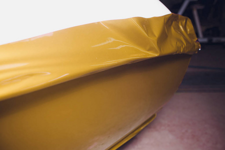 汽车包装专家把乙烯基箔或薄膜上的汽车包装保护膜游艇, 船, 船, 汽车, 移动家庭。黄金影片手拉扯