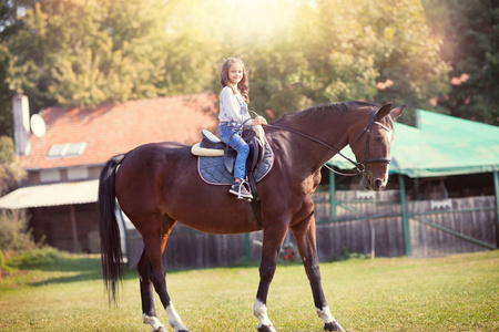 骑着马的小女孩在农场里骑马很开心照片