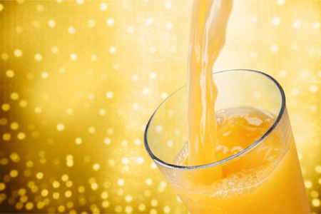 把新鲜美味的橙汁倒入杯中