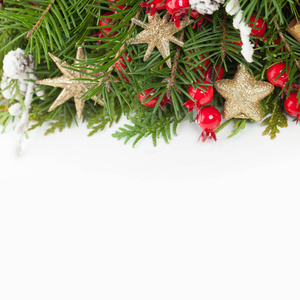 圣诞背景边框与复制空间。 绿色圣诞树枝红色浆果和白色背景的新年装饰