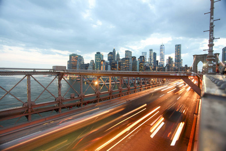 纽约夜间布鲁克林桥上的建筑和交通。