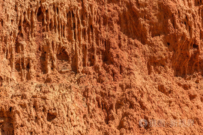 从红土,粘土和石头的山坡纹理中抽象出的自然背景