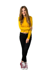 一个年轻女孩穿着黄色毛衣，在孤立的白色背景上表情愉快