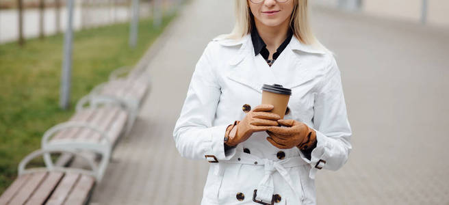 办公楼附近有咖啡杯的漂亮女人.照片