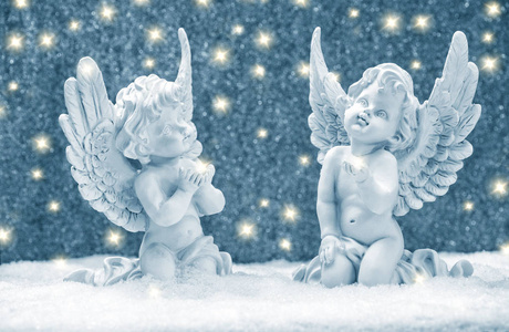 带着金色灯光在雪地里的小守护天使. 圣诞装饰照片