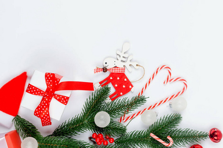 圣诞节装饰背景与红白圣诞礼物球和玩具冷杉树枝锥白色背景。 卡假日概念。 复制空间顶部视图。
