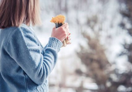 女人拿着一束黄花