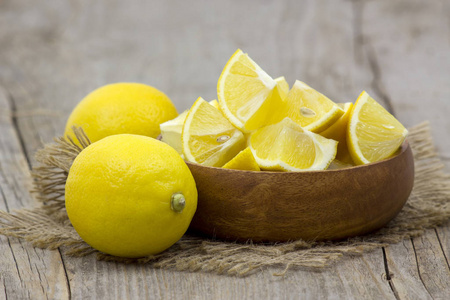 木制背景碗里的新鲜柠檬