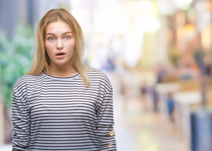 年轻的白种人女人在孤立的背景下害怕和震惊，惊讶的表情，恐惧和兴奋的脸。