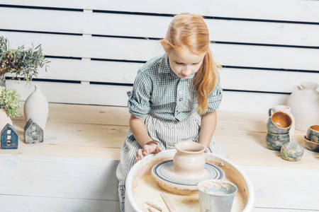 小女孩看着制作的陶器图片