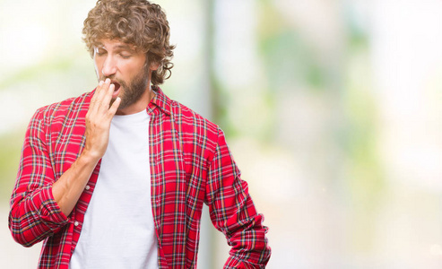 英俊的西班牙裔模特男子在孤立的背景下无聊地打哈欠，疲惫地用手捂住嘴。 不安和困倦。