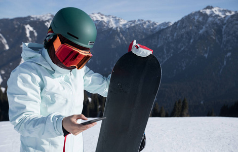 在冬季山顶使用smatphone的一个滑雪板
