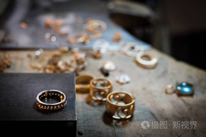 金环在旧工作台上,在一个正宗的珠宝车间的背景下,其他黄金珠宝店进行