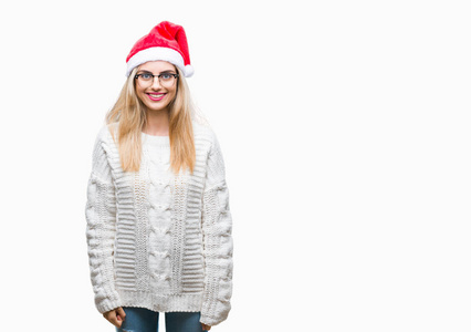 年轻漂亮的金发女人戴着圣诞帽，在孤立的背景上，脸上带着快乐和凉爽的微笑。很幸运的人。