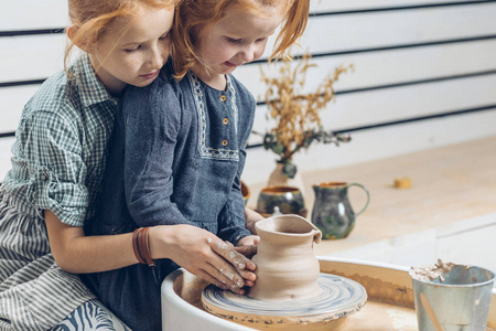 可爱的年轻女孩创造一个陶瓷花瓶