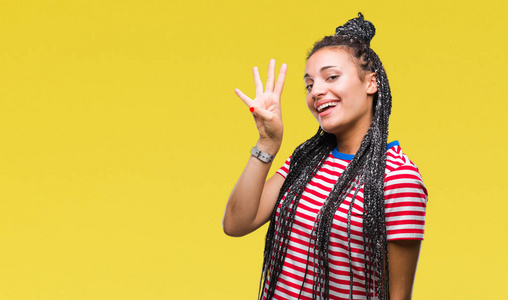 年轻的辫子非洲裔美国女孩在孤立的背景显示和手指第四，同时微笑自信和快乐。