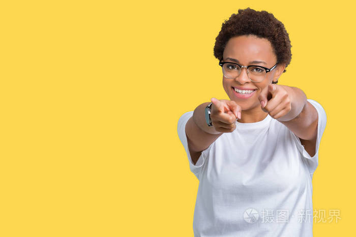 美丽的年轻的非洲裔美国妇女戴着眼镜,背景偏僻,手指指着你和相机