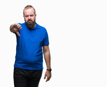 年轻的白种人臀部男子穿着蓝色衬衫，在孤立的背景上，看上去不高兴和愤怒，表现出拒绝和消极的拇指向下的手势。 不好的表情。