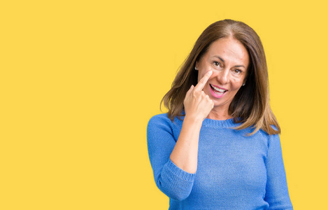 中年美丽的女人穿着冬天的毛衣,背景偏僻,眼睛盯着你看,手势可疑的