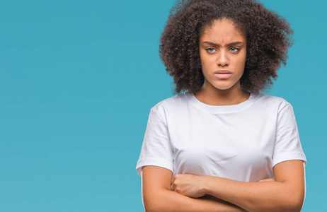年轻的非洲美国妇女超过孤立的背景怀疑和紧张的不赞成的表情在脸上交叉的手臂。 消极的人。