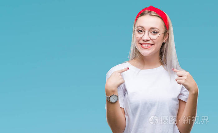 女人戴着眼镜,在孤立的背景上看着自信,脸上带着微笑,用手指指着自己