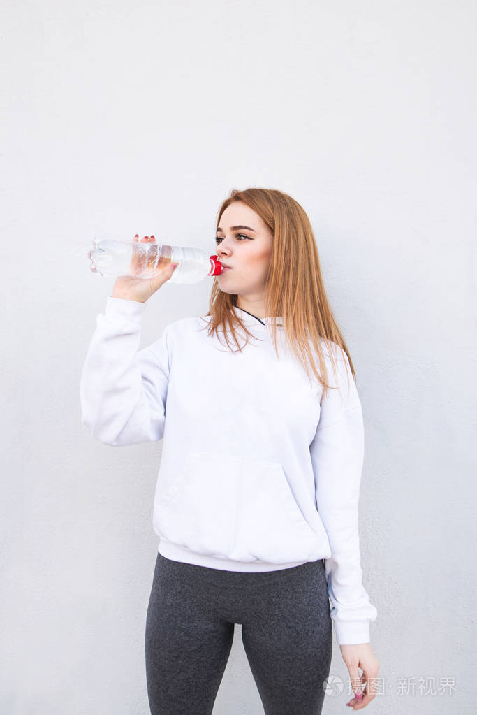 跑步女孩在白色背景上喝水.