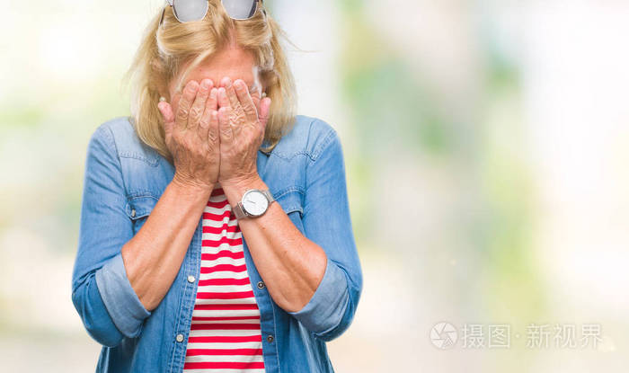中年金发女人在孤立的背景上悲伤的表情用手捂住脸一边哭抑郁的概念