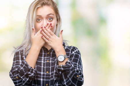 年轻的金发女人在孤立的背景下震惊地用手捂住嘴，因为错误。 秘密概念。