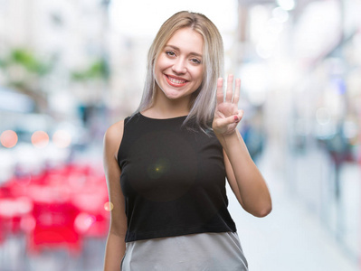 年轻的金发女子在孤立的背景显示和指着第三个手指，同时微笑自信和快乐。