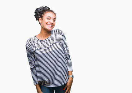 年轻的辫子非洲裔美国女孩穿着毛衣，在孤立的背景下，看着一边，脸上带着微笑，自然的表情。充满自信的笑。