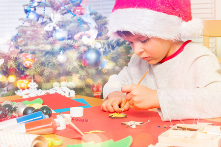 s costume decorating holiday ornaments with paintbrush, sitting 