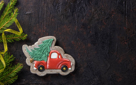 圣诞自制姜饼饼干在黑色背景上。 上面的风景。 圣诞树卡车