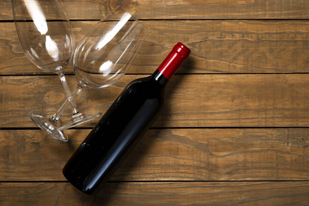 木制背景上的一瓶葡萄酒和眼镜。 顶部视图与复制空间。