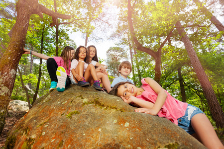 一大群孩子坐在石头上的肖像，一起参加暑假旅行
