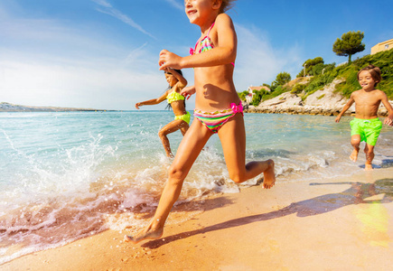 夏天在海滩上玩赛车游戏的快乐男孩和女孩的肖像。