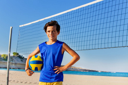 少年沙滩排球运动员站在网旁的球的肖像