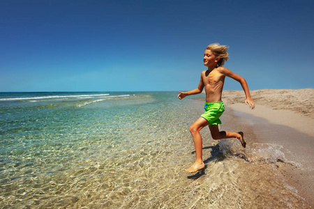 小男孩准备在海滩上度过夏天跳进海里的侧景肖像