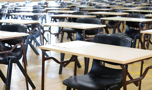 大的考场大厅和考场桌子排成一排,准备让高中的学生来坐他们的考试