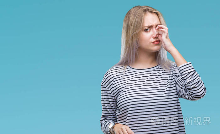 年轻的金发女人在孤立的背景上闻到一些臭味和令人恶心的难以忍受的